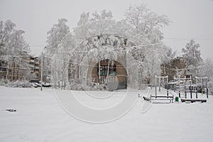 Old Soviet five-story house among snow-covered trees in winter