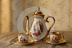 Old soviet gilded porcelain teapot and two cups.