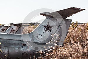 Old soviet L-29 plane fuselage empennage in field photo