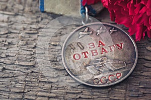 The Old Soviet Medal For Bravery of the Second World War with a red carnation, Victory Day May 9 postcard concept