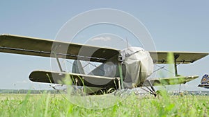 Old Soviet Military Plane Antonov An-2 Landing on Grass Blue Sky Background