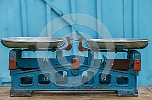 Old Soviet scales with aluminum bowls against the background of a light blue wooden textured wall