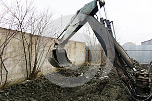 An old Soviet tractor digs and loads waste stone processing