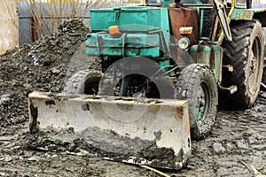 An old Soviet tractor digs and loads waste stone processing