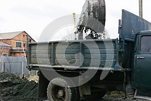 An old Soviet tractor digs and loads waste stone processing