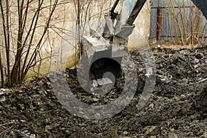 An old Soviet tractor digs and loads waste stone processing