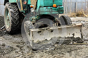 An old Soviet tractor digs and loads waste stone processing