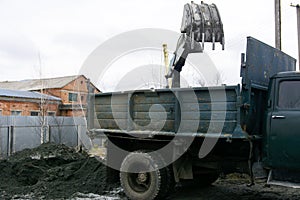 An old Soviet tractor digs and loads waste stone processing