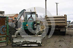 An old Soviet tractor digs and loads waste stone processing