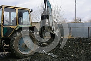 An old Soviet tractor digs and loads waste stone processing