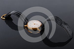 Old soviet wristwatch on black glossy background