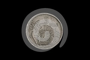 An old Spanish coin featuring Francisco Franco on a black background