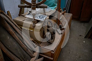 Old spinning wheel machine exposed on a wooden background