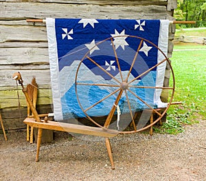 An old spinning wheel and a quilt on display at an historic site in virginia