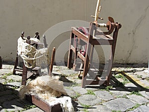 Old spinning wheel, raw wool yarn and wool to card