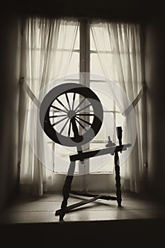 Old Spinning Wheel in Window Well