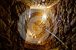 Old spiral staircase inside red brick tower. Turaida Castle tower