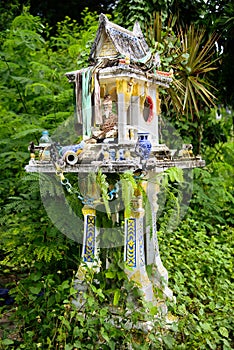 Old spirit house left neglected in bushes.