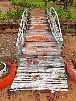 Old spoiled wooden footbridge. Small bridge in rural garden. Asian, oriental and Vietnamese culture