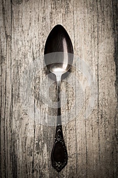 Old spoon on wooden background.