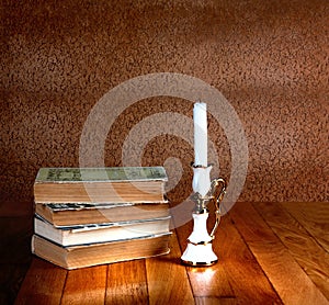 Old stack of books with candlestick
