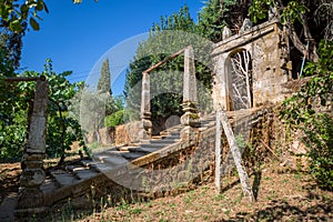 Old staircase in granite and stone pillars and arch gate, typically Mediterranean, inside the gardens at the Solar de Mateus