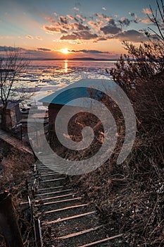 Old staircase to the house by the sea in the sunset light.