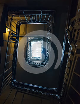 An old stairway in the dark with a ceiling light