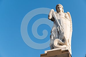 Old statue of the Archangel Saint Michael fighting the dragon