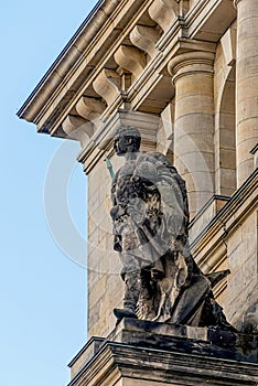 Old statue of Roman soldier with helmet and spear at the wall of Reichstag building, German Parliament, Berlin, Germany