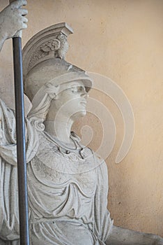 Old statue of a sensual Roman woman warrior, Amazonian, as defender with spear and helmet, details, closeup, with copy space