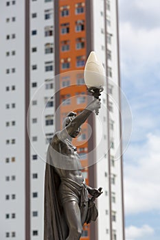 Old statue and street light with modern building, Manaus