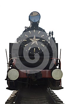 An old steam locomotive stands in the bright sun on rails on a clean white background with clipping. Photographed from the front