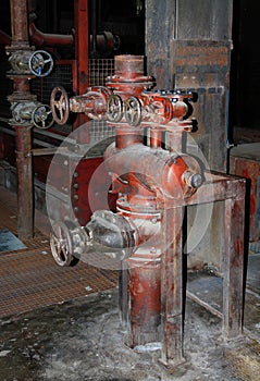 An old steam shut-off valve in a disused industrial hall.