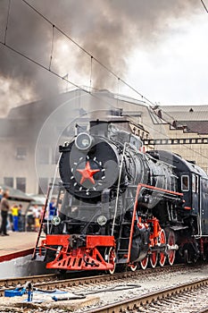 Old steam train is leaving a station