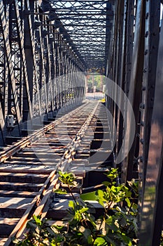 Old steel bridge with railway tracks and grass