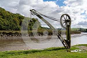 Old steel cargo winch on harbour by tidal River Tamar in Devon