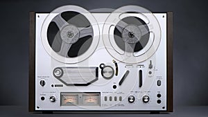 Old steel reel-to-reel tape recorder plays on a dark background in 4K. Front view