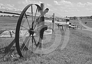 Old steel spoked wheel leaning on a log fine. black and white