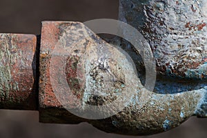 Old steel water tap of an outdated design outdoors, covered in peeling paint, rust marks