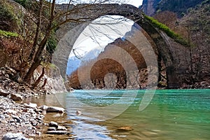 Old stone arch bridge over Aoos river, in Konitsa, Greece