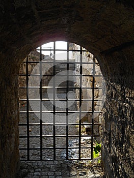 Old stone arch with iron grid gate