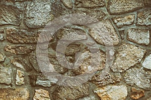 Old stone background of cobblestones linked with cement toned design