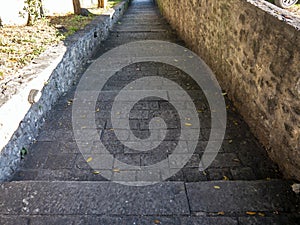 Old stone blocks steps of stairway down with stone walls and green moss photo