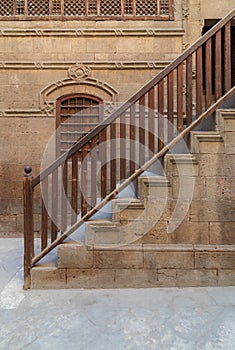 Old stone bricks wall  and, window and staircase with wooden balustrade photo