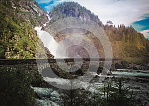 Old stone bridge on a background of a waterfall