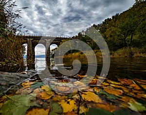 Old stone bridge at Baikal lake with autumn leaves