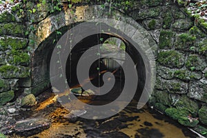 Old stone bridge over Konsky creek in winter day in Sumava national park