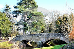 old stone bridge and tree reflections in a river