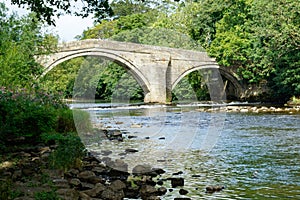 An Old Stone Bridge with Two Arches Crossing a River.